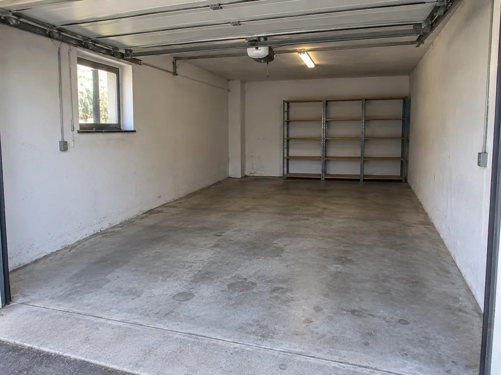 Dieselbe Garage nach der Räumung, vollständig leer und gekehrt