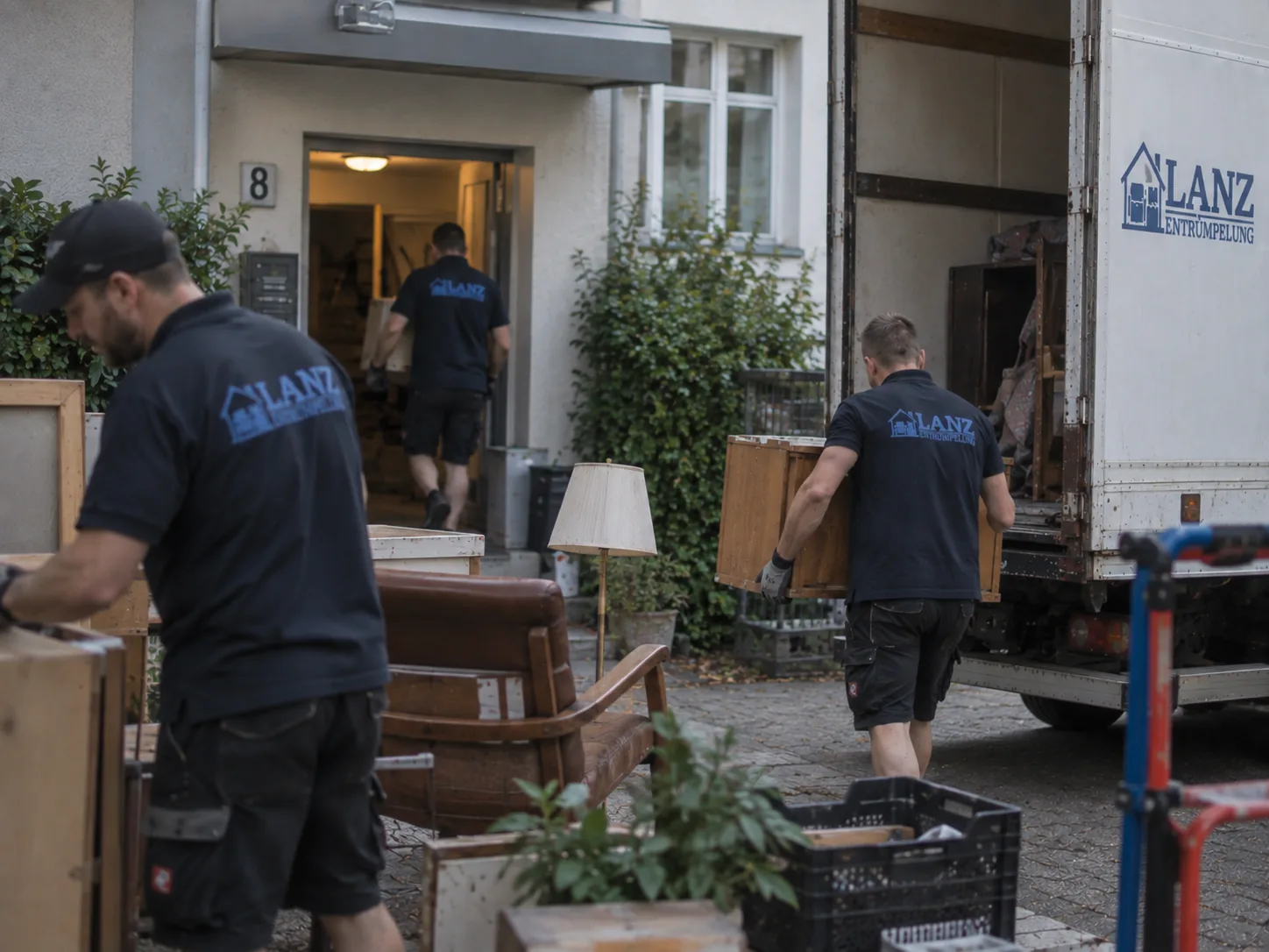 Mitarbeiter von Lanz Entrümpelung verladen Möbel und Kisten in einen Transporter